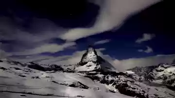 Panorama bei Nacht vom Matterhorn mit faszinierenden Wolken und Sternenhimmel